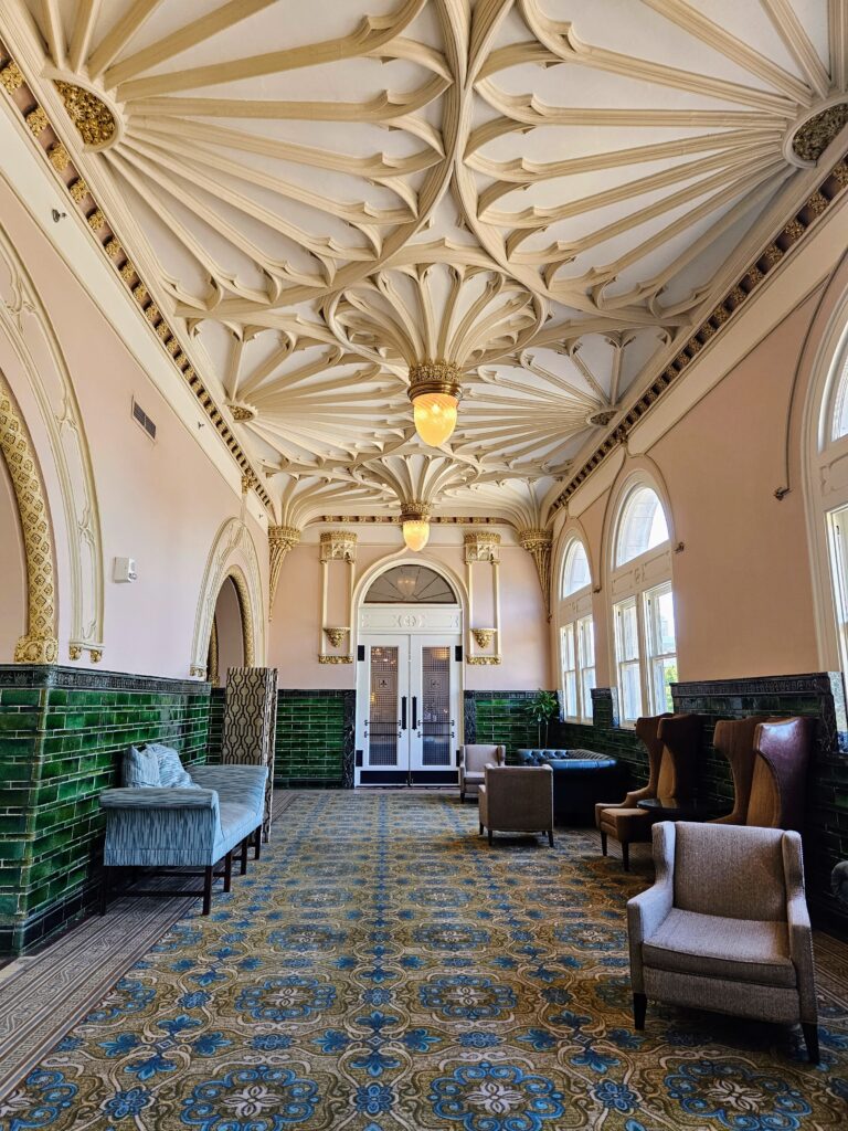 An elegant hotel lobby with ceiling decorate with flower petal design.