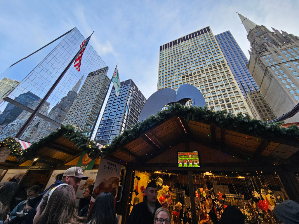 Chicago's Christkindl Christmas Market stalls with Chicago architecture and skyscrapers in the background.
