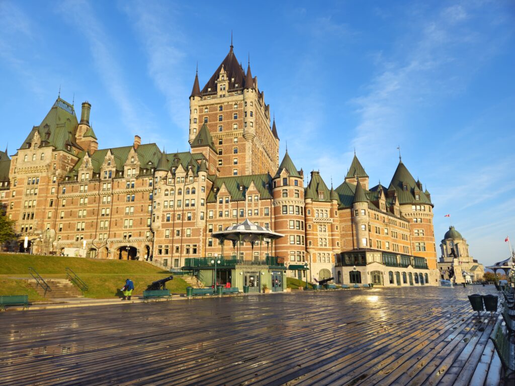 The historic and castle-like Chateau Frontenac at sunrise in Quebec City as seen from Dufferin Terrace. The Old Post Office and Statue of Samuel de Champlain can be seen the far distance.